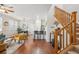 Bright living room flows to kitchen, with hardwood floors, modern decor, and staircase at 2362 Xanthia Way, Denver, CO 80238