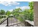 Charming balcony with metal railing, seating, and views of lush greenery and a blue sky at 915 26Th St, Denver, CO 80205