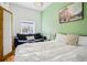 Bedroom featuring a comfortable bed, dark sofa, and large window at 915 26Th St, Denver, CO 80205