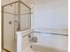 Bathroom featuring bathtub with glass shower door, white tile and a modern faucet at 13456 Via Varra # 315, Broomfield, CO 80020