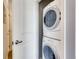 Efficient laundry area with stacked washer and dryer units next to a white door at 13456 Via Varra # 315, Broomfield, CO 80020