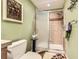 Bright bathroom featuring tiled shower with glass door and earthy green walls at 8385 Briar Trace Dr, Castle Pines, CO 80108