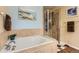 Bathroom featuring soaking tub and glass shower, tiled walls, and wood floor at 8385 Briar Trace Dr, Castle Pines, CO 80108