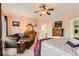 Comfortable bedroom with sitting area and a full-size bed, dresser, and ceiling fan at 8385 Briar Trace Dr, Castle Pines, CO 80108