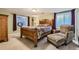 Cozy bedroom with wood frame bed, chair, and a window providing natural light at 8385 Briar Trace Dr, Castle Pines, CO 80108