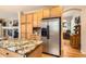 Bright kitchen boasts stainless steel appliances, ample wood cabinets, and stylish granite island at 8385 Briar Trace Dr, Castle Pines, CO 80108