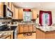 Well-lit kitchen with granite countertops, wood cabinets, tile backsplash, and stainless steel appliances at 8385 Briar Trace Dr, Castle Pines, CO 80108