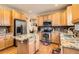 Spacious kitchen featuring stainless steel appliances, wood cabinets, an island and granite countertops at 8385 Briar Trace Dr, Castle Pines, CO 80108