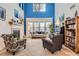 Bright living room boasting a fireplace, piano, large windows and cozy seating on neutral carpet at 8385 Briar Trace Dr, Castle Pines, CO 80108