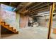 Unfinished basement with exposed brick walls and wooden stairs at 1340 N Gilpin St, Denver, CO 80218