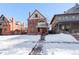 Brick two-story home with a wrap-around porch and snow-covered lawn at 1340 N Gilpin St, Denver, CO 80218