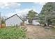 Wide backyard shot shows house with detached garage and sheds, offering space for various outdoor activities at 796 S Bristol St, Lakewood, CO 80228