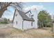 Back exterior of a charming two-story white painted brick home with a black roof and mature landscaping at 796 S Bristol St, Lakewood, CO 80228
