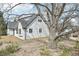 Charming exterior view of a white painted home with a dark roof and mature tree in the front yard at 796 S Bristol St, Lakewood, CO 80228