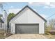Detached garage with gray door and white siding, positioned next to the main house for convenient access at 796 S Bristol St, Lakewood, CO 80228