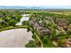 Aerial view showcasing a townhome community nestled among lush greenery and a serene lake at 3240 W 114Th Cir # D, Westminster, CO 80031