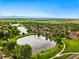 Picturesque aerial shot of townhomes and community ponds nestled within vibrant green spaces, under a clear sky at 3240 W 114Th Cir # D, Westminster, CO 80031