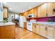 Traditional kitchen with wood cabinets, white appliances, and view to a dining nook at 3240 W 114Th Cir # D, Westminster, CO 80031