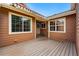 Cozy patio with wood flooring, surrounded by the exterior of a townhome with awning, windows, and entry door at 3240 W 114Th Cir # D, Westminster, CO 80031