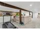 Finished basement with exposed beams featuring a seating area and a home workout space at 2765 W Denver Pl, Denver, CO 80211