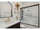Bathroom featuring glass-enclosed shower with window, black vanity, and gold fixtures at 2765 W Denver Pl, Denver, CO 80211