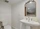 Powder room showcasing a pedestal sink, decorative mirror, and a modern toilet at 2765 W Denver Pl, Denver, CO 80211