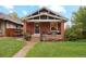 Charming red brick bungalow with a cozy front porch and well-maintained lawn at 2765 W Denver Pl, Denver, CO 80211