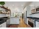 Spacious kitchen boasting stainless steel appliances, open shelving, and hardwood floors at 2765 W Denver Pl, Denver, CO 80211