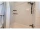 Bathroom tub and shower with white subway tiles, black shower head, and storage shelves at 3775 S Green Ct, Englewood, CO 80110
