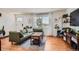 Bright living room featuring hardwood floors, a comfortable green sofa, and large windows at 3775 S Green Ct, Englewood, CO 80110