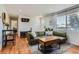 Inviting living room showcases hardwood floors, a cozy green sofa, and a view into the home at 3775 S Green Ct, Englewood, CO 80110