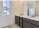 Elegant bathroom featuring a double vanity, stylish mirrors, and a window providing natural light at 1978 S Haleyville Way, Aurora, CO 80018
