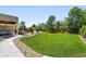 Expansive backyard featuring a lush lawn, stone fire pit, patio, and mature trees at 16975 Melody Dr, Broomfield, CO 80023