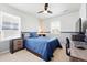 Well lit bedroom with a ceiling fan, two windows and a modern desk setup at 16975 Melody Dr, Broomfield, CO 80023