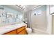 Bright bathroom with a single sink vanity, framed mirror, white tiled walls, and a shower/tub combo at 4164 E 135Th Pl, Thornton, CO 80241
