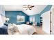 Cozy bedroom featuring a pitched ceiling, ceiling fan, large window, and blue accent wall at 4164 E 135Th Pl, Thornton, CO 80241