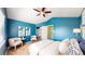 Cozy bedroom featuring a pitched ceiling, ceiling fan, large window, and blue accent wall at 4164 E 135Th Pl, Thornton, CO 80241