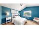 Cozy bedroom featuring a pitched ceiling, ceiling fan, large window, and blue accent wall at 4164 E 135Th Pl, Thornton, CO 80241