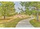A winding walking path surrounded by lush greenery and mature trees, creating a peaceful and inviting park setting at 4164 E 135Th Pl, Thornton, CO 80241