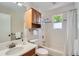 Well-lit bathroom featuring a shower over bath, storage cabinet, and vanity at 1367 Teller St, Lakewood, CO 80214