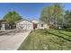 Charming single-story home with a well-manicured lawn, mature trees, and an attached two-car garage at 1367 Teller St, Lakewood, CO 80214