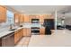 Bright kitchen features wood cabinets, stainless steel appliances, and white countertops at 1367 Teller St, Lakewood, CO 80214
