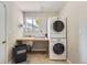 Laundry room with a stacked washer and dryer and a sink area for convenience at 1367 Teller St, Lakewood, CO 80214