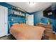 Charming bedroom featuring blue walls, wood shelves with books, and a mounted TV at 2870 Pontiac St, Denver, CO 80207