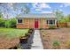 Charming brick home featuring a red front door, meticulous landscaping, and a well-maintained walkway at 2870 Pontiac St, Denver, CO 80207