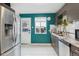 Well-lit kitchen featuring stainless steel appliances, teal walls, and backyard access at 2870 Pontiac St, Denver, CO 80207