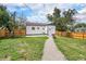 Fenced backyard boasts lush grass, gravel path, and exterior view of the home at 2 S Knox Ct, Denver, CO 80219