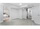 Open basement space with tile flooring, leading to a cozy bedroom, and utility area at 2 S Knox Ct, Denver, CO 80219