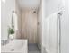 A tile-lined shower stands next to a modern sink in this bathroom at 2 S Knox Ct, Denver, CO 80219