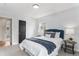 Well-lit bedroom featuring a black door, blue headboard, and plush carpeting at 2 S Knox Ct, Denver, CO 80219